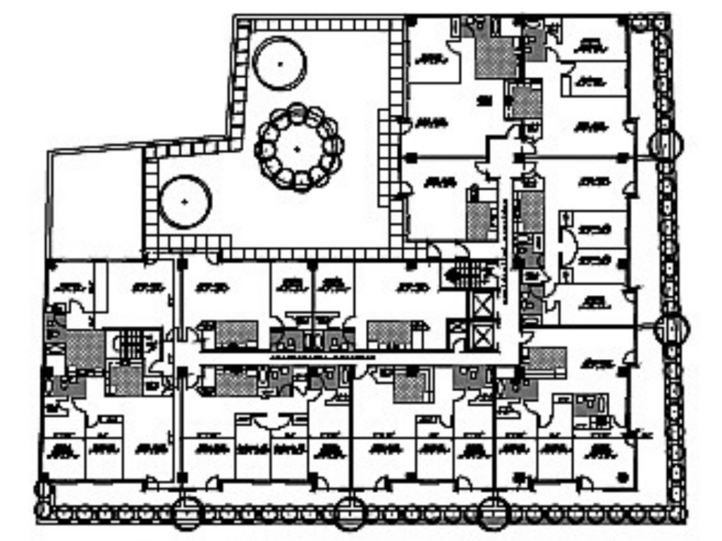 Architectural floor plan showing residential units arranged around a landscaped courtyard with elevators, corridors, and common circulation spaces.